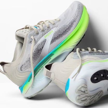 Gray and white running shoes with green and blue accents on a light gray background