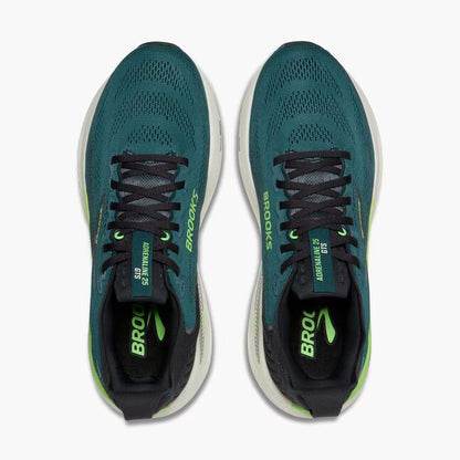 Pair of teal running shoes with black and green accents on a white background
