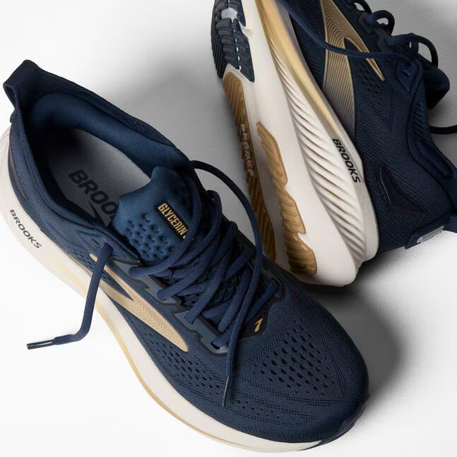 Navy and white running shoes with 'Brooks' branding on a light gray background