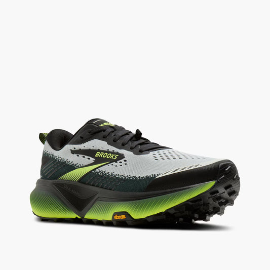 Brooks trail running shoe in light gray and black with bright neon yellow-green accents on the midsole and logo, shown from a side profile on a light gray background.