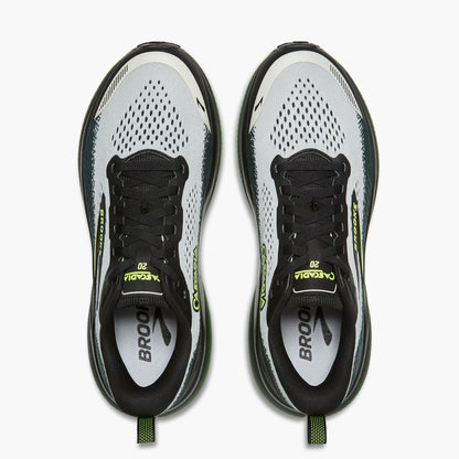 A pair of Brooks Cascadia 20 running shoes shown from a top-down view against a clean white background. The shoes feature a white and gray mesh upper with black overlays, black laces, and bright neon yellow-green accents on the tongue, heel, and pull tabs.