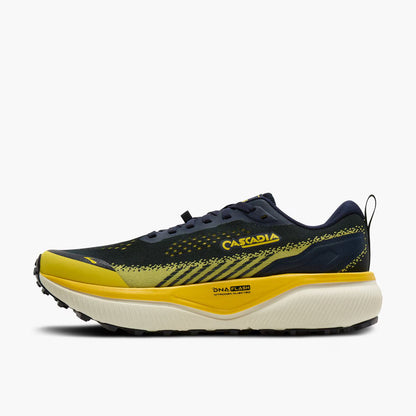 A single Brooks Cascadia 20 running shoe shown in profile against a light gray background. The shoe features a dark navy blue upper with yellow accents, a thick yellow midsole, and a cream-colored cushioned outsole.