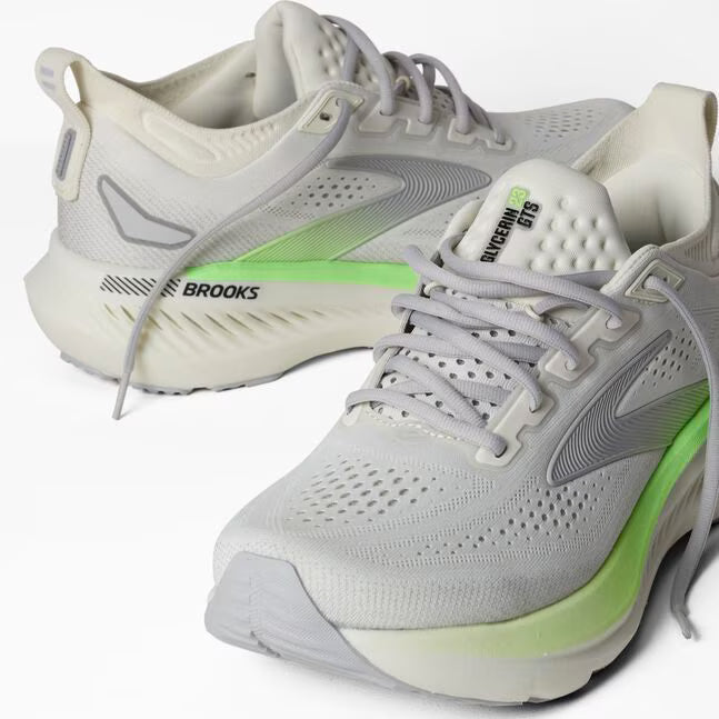 Pair of gray and green running shoes with 'Brooks' branding on a white background