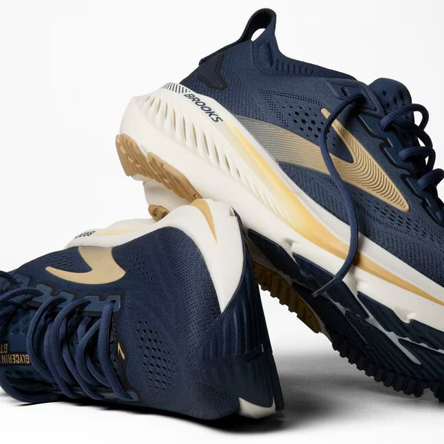 Navy and gold running shoes on a white background