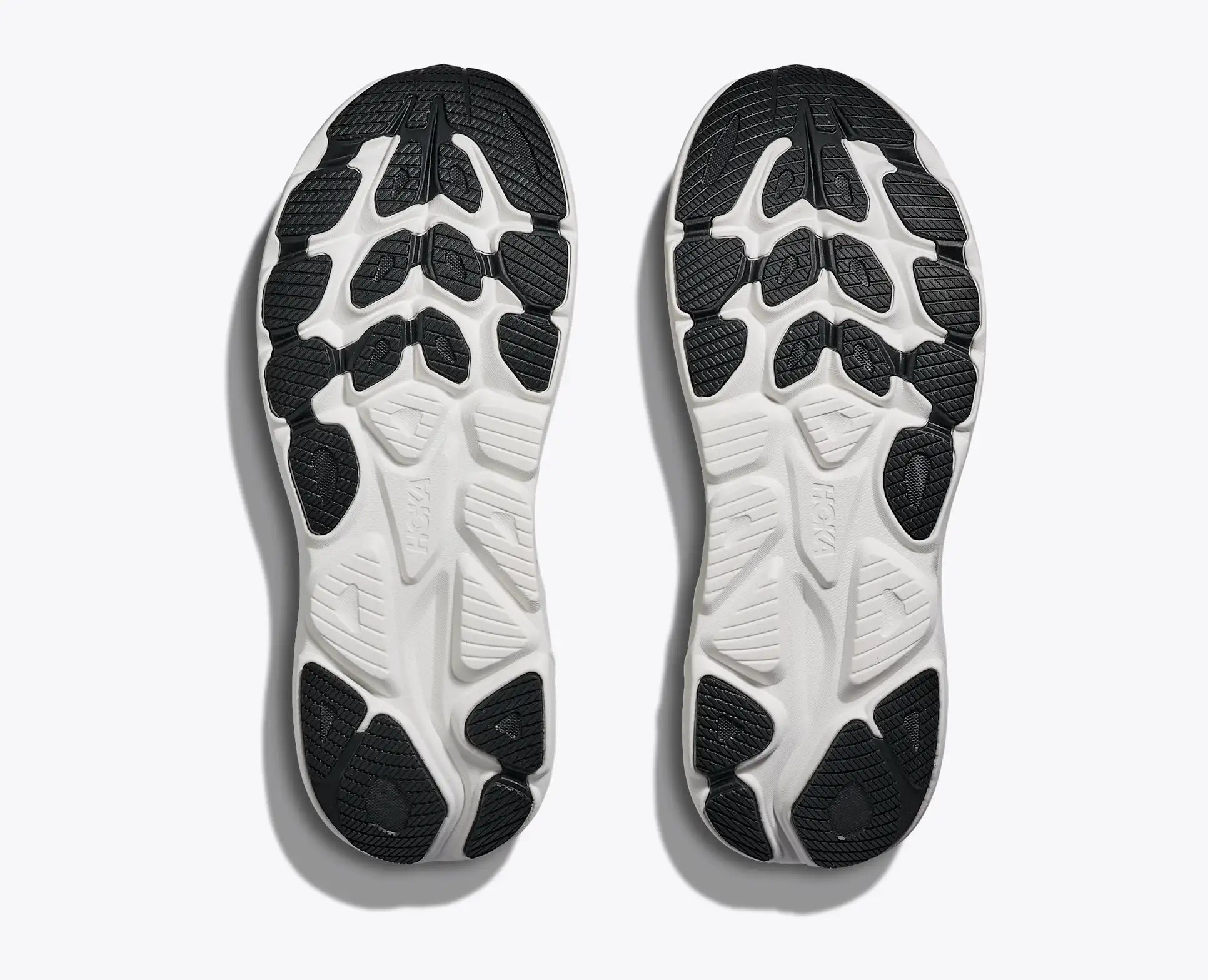 Close-up of a pair of black and white Hoka Clifton 10 men's  athletic shoes on a light gray background