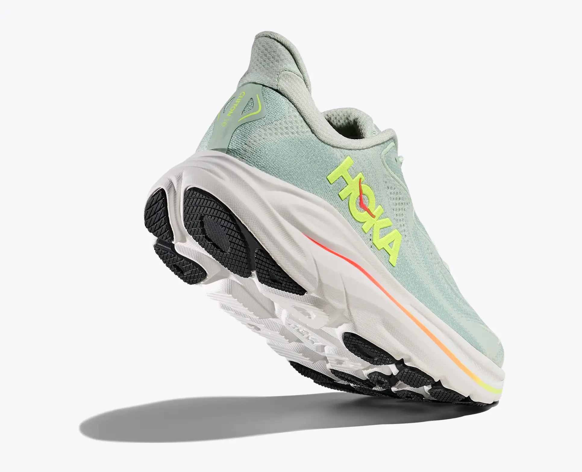 Light blue running shoe with black sole and neon green 'Hoka' branding on a white background