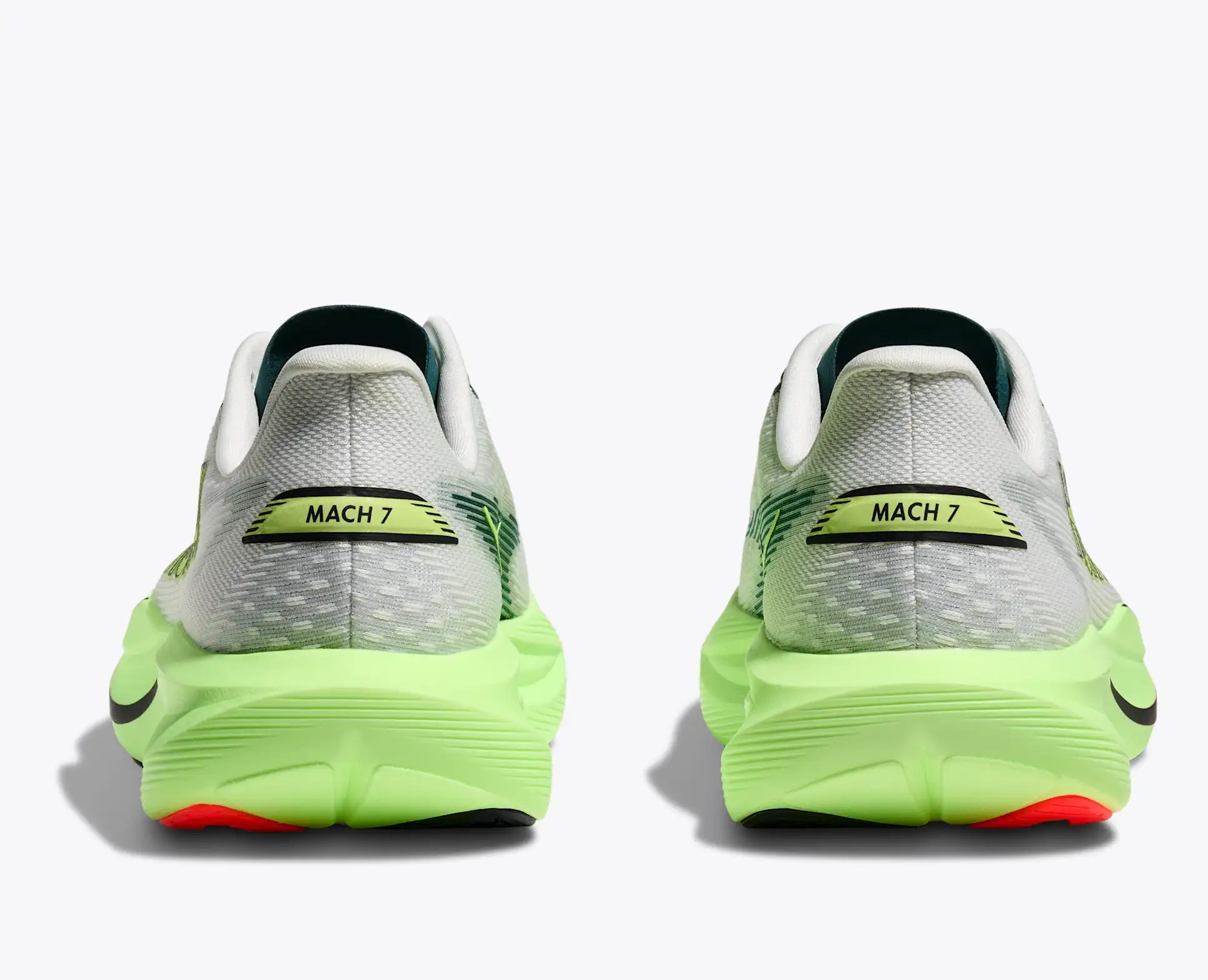 Pair of running shoes with bright green soles on a white background