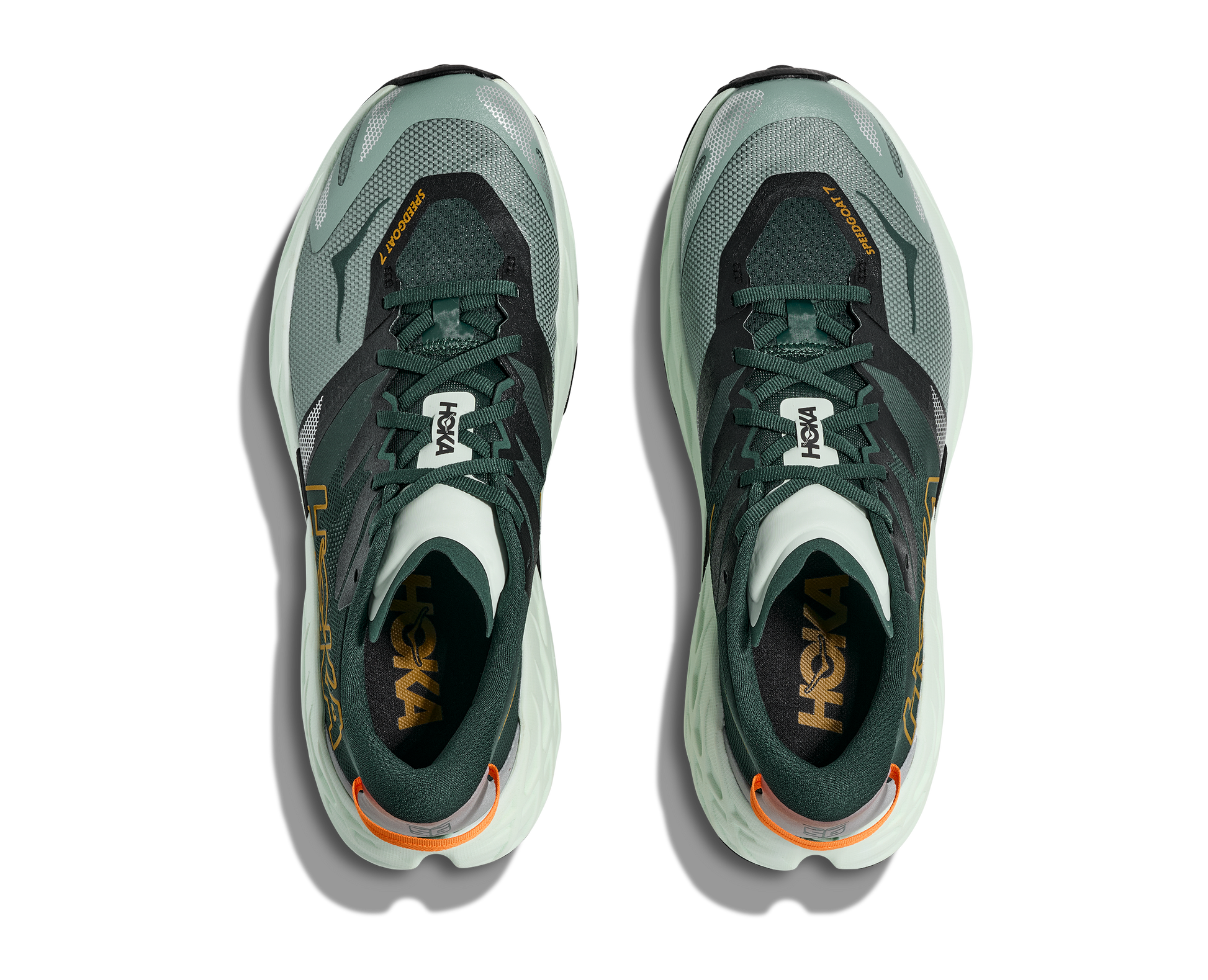 Pair of green athletic shoes with orange accents on a white background