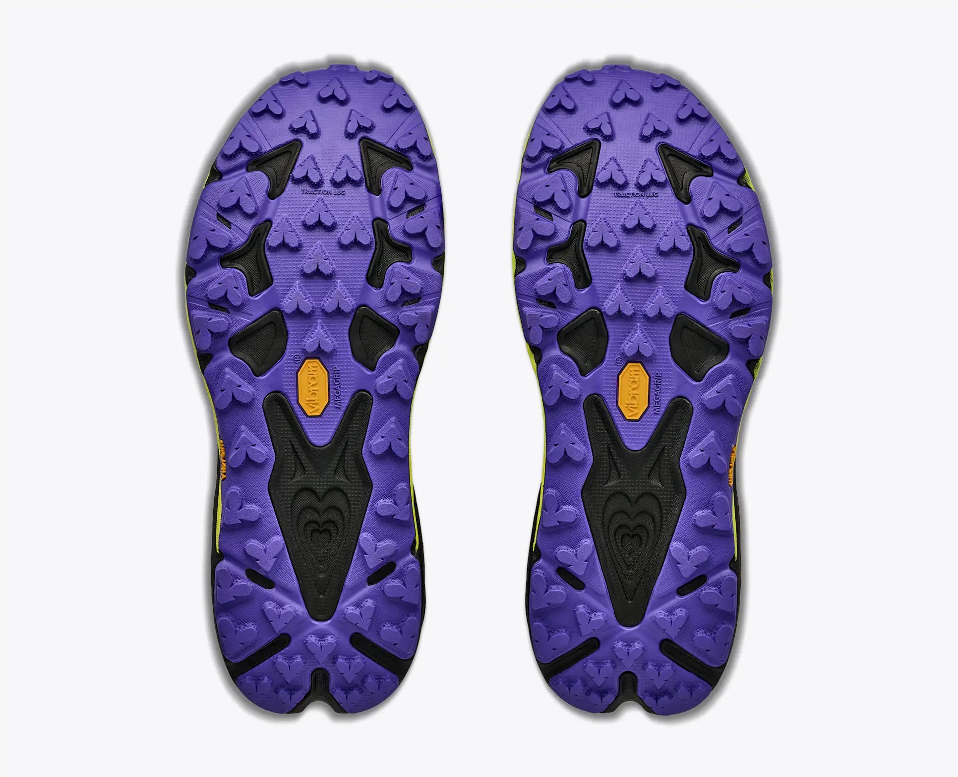 The outsoles of a pair of Hoka Men's Speedgoat 7 purple and black athletic shoes, showing the tread pattern and Vibram logo, on a light gray background.