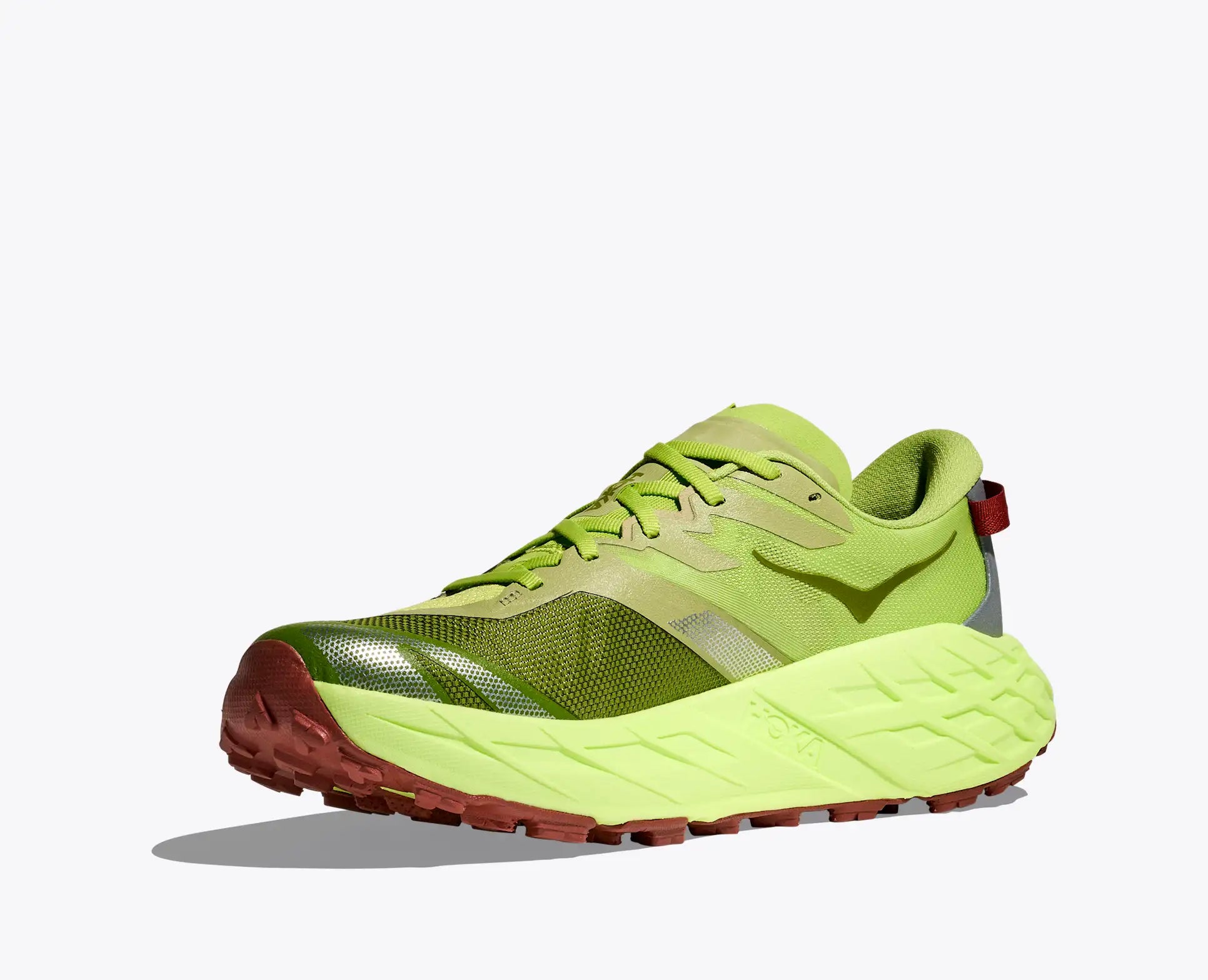 Green running shoe with brown sole on a white background