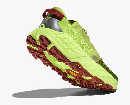 Green and red athletic shoe with unique tread pattern on a white background