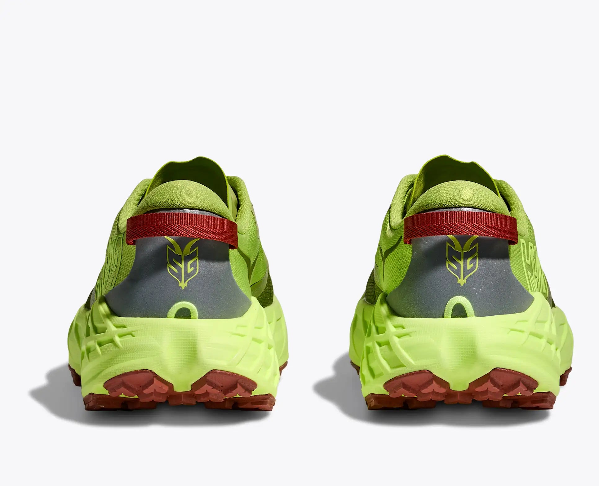 Pair of bright green athletic shoes with red and gray accents on a white background