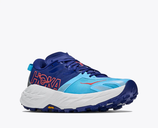 A Hoka Speedgoat trail running shoe in vibrant blue, light blue, and white, featuring a thick white midsole and a dark blue outsole, shown from a side profile on a light gray background.