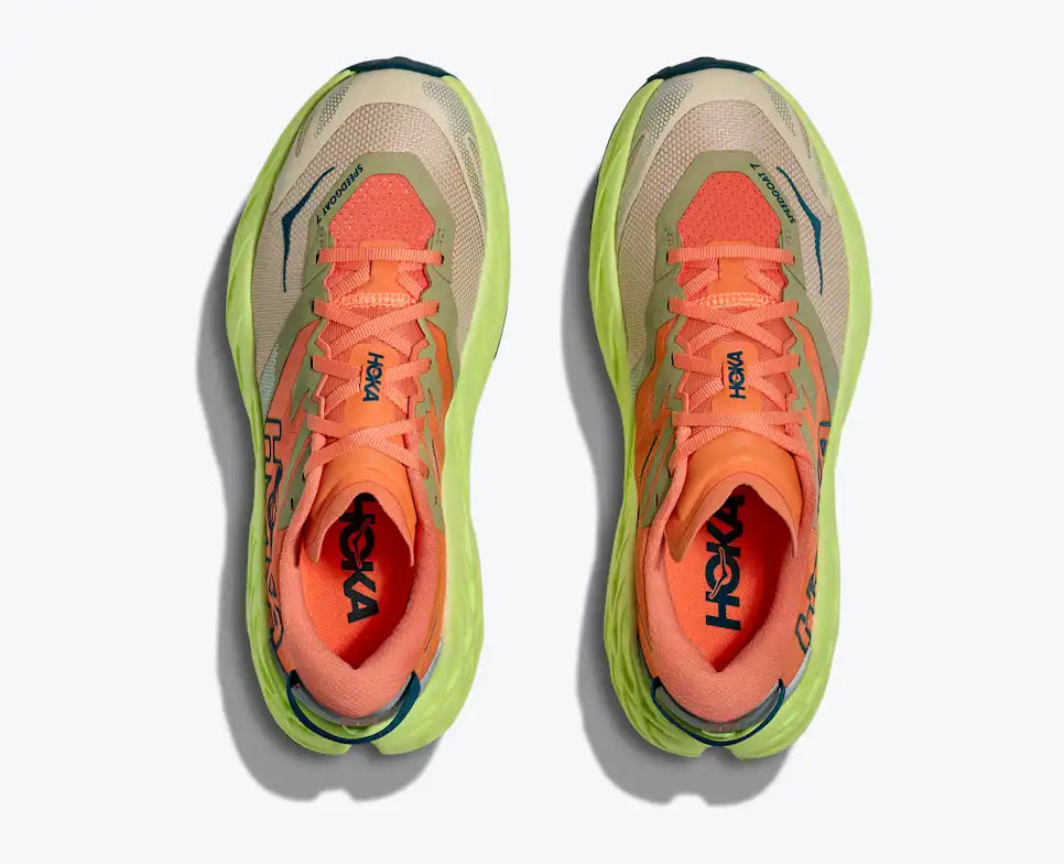 Pair of orange running shoes with green accents on a white background