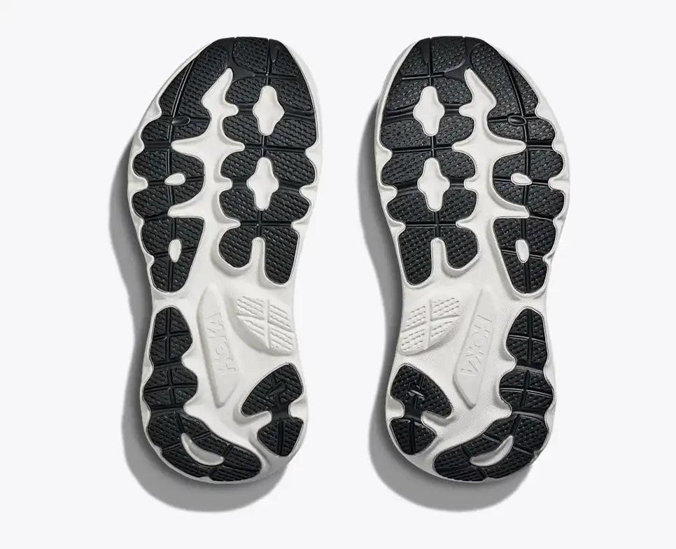 Close-up of a pair of black and white shoe soles on a light gray background