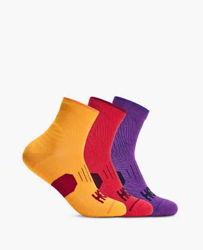 Three pairs of low-cut athletic socks in yellow, red, and purple, arranged in a fan shape against a plain white background.