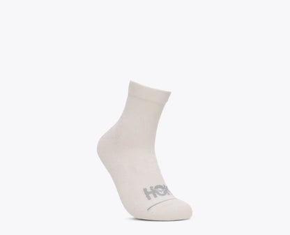 A single white ankle sock with a gray HOKA logo printed on the toe, shown against a solid white background.