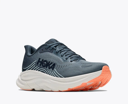 A HOKA running shoe in slate blue-gray with a thick white midsole and a bright orange outsole, shown from a side profile on a light gray background.
