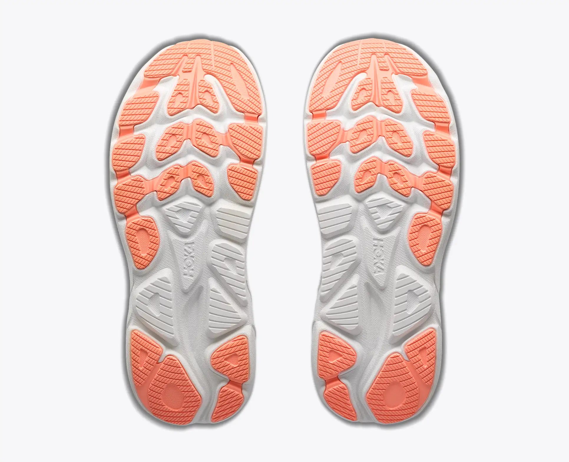 A pair of athletic shoes shown from the sole view, featuring a white and gray cushioned midsole with bright coral orange outsole tread, set against a clean light gray background.