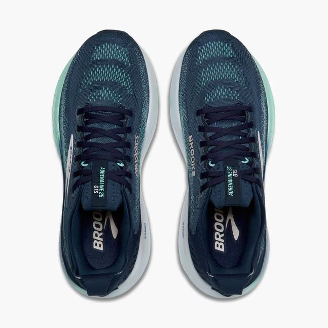 Pair of navy running shoes with white soles on a white background