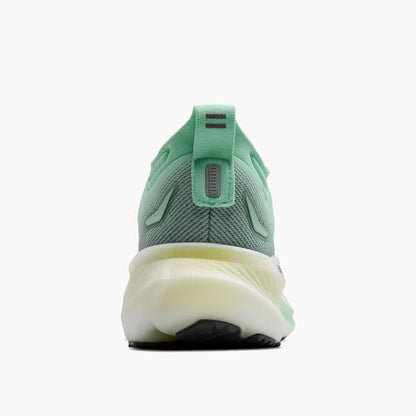 Green running shoe with a white sole on a white background