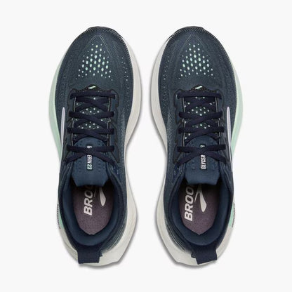 Pair of navy running shoes with white soles on a white background
