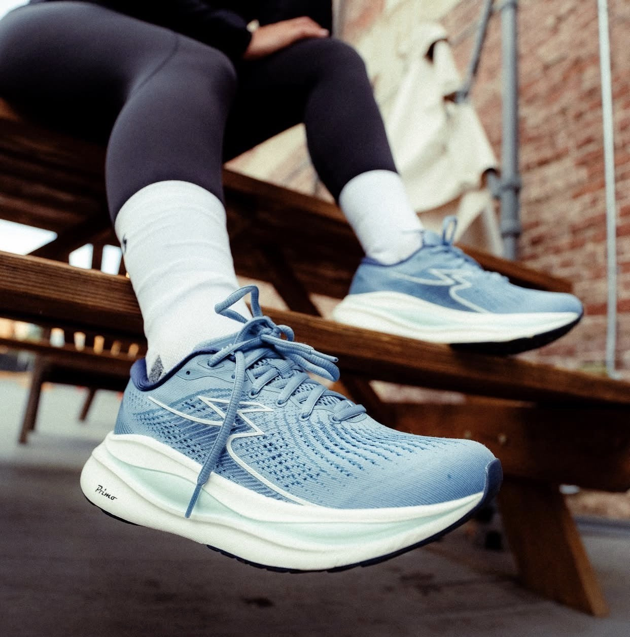 Blue 361 Ventus running shoes worn by a person sitting on a wooden bench.