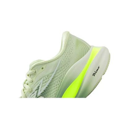 Light green athletic shoe with a bright yellow sole on a white background