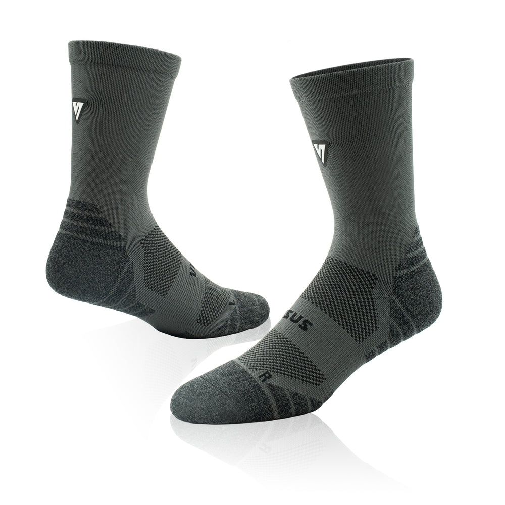 A pair of dark gray athletic crew socks with textured knit patterns and a small white logo on the side, displayed on a clean white background with a soft reflection.