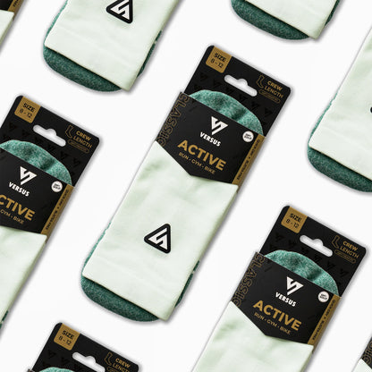 Green socks with green accents in packaging labeled 'Versus Active' on a white background.