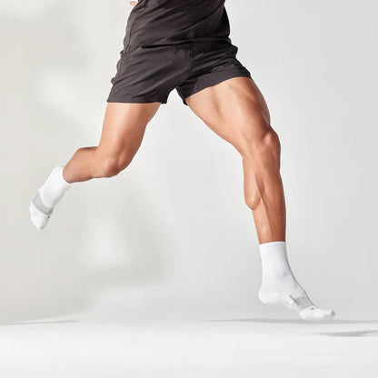 Person wearing black shorts and white socks on a light gray background