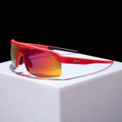 Goodr Bolt G: Dante’s Shin Splint Inferno Red sunglasses with multicolored lenses on a white block against a black background