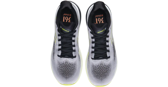 Pair of white athletic shoes with black accents on a white background
