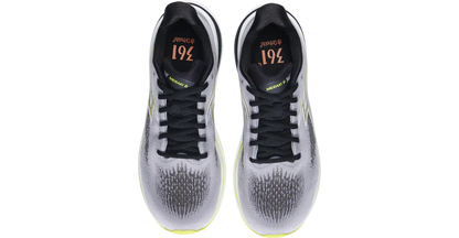 Pair of white athletic shoes with black accents on a white background