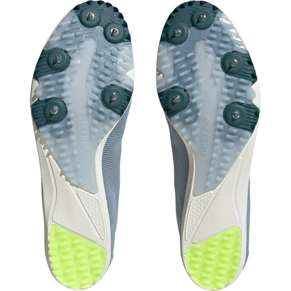 Close-up of a pair of cleats with green outsoles on a white background