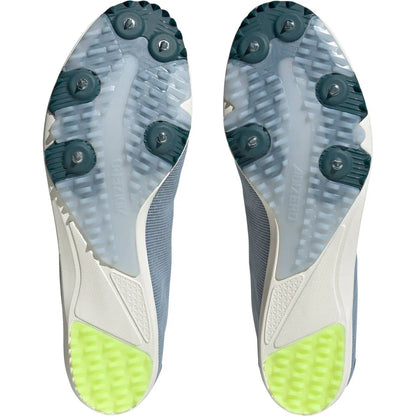 Close-up of a pair of cleats with green outsoles on a white background