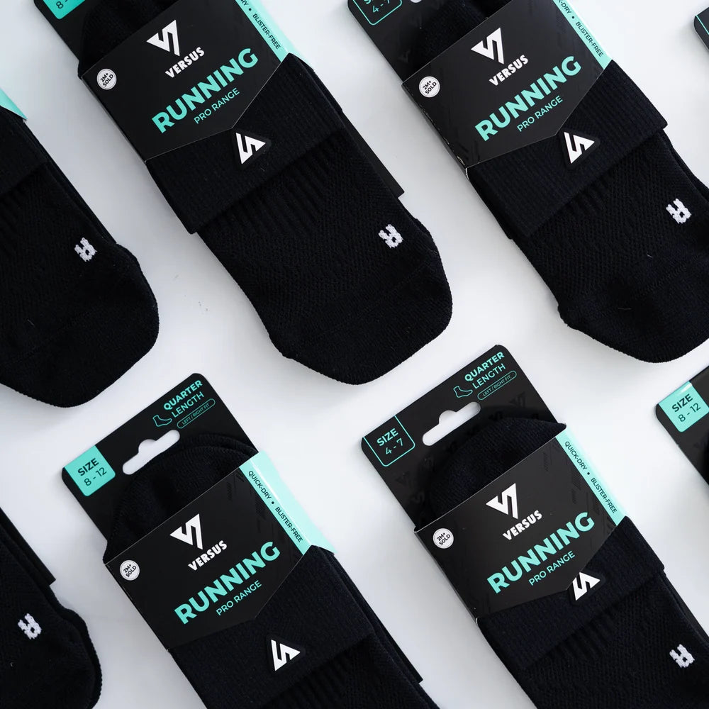Black running socks with Versus branding on packaging against a white background