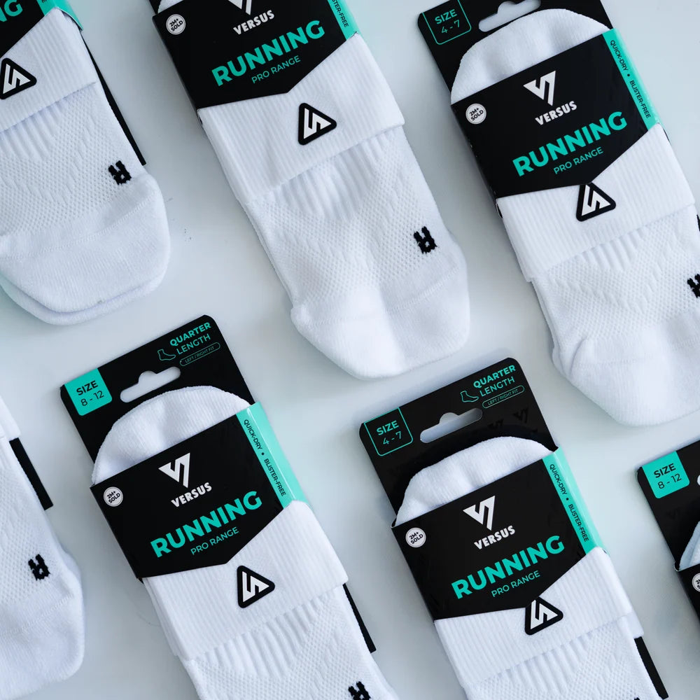White socks with black packaging labeled 'Versus Running' on a light gray background