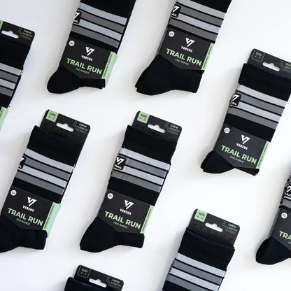 Packaged black socks with gray stripes on a white background